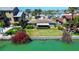 Waterfront home featuring lush landscaping and a vibrant bougainvillea in a tropical setting at 501 Crystal Dr, Madeira Beach, FL 33708
