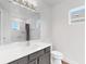 Clean and bright bathroom features a sleek vanity, tiled shower, and a window offering natural light at 5307 Wishing Arch Dr, Apollo Beach, FL 33572