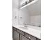 Modern bathroom with a gray vanity, white countertop, and a large mirror with stylish lighting at 5307 Wishing Arch Dr, Apollo Beach, FL 33572