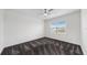 Neutral bedroom featuring large window, ceiling fan, and modern carpet at 5307 Wishing Arch Dr, Apollo Beach, FL 33572