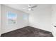 Bright bedroom features neutral carpeting, a modern ceiling fan, and two windows overlooking the neighborhood at 5307 Wishing Arch Dr, Apollo Beach, FL 33572