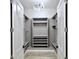 Spacious walk-in closet boasts custom shelving and ample storage space, illuminated by a modern light fixture at 5307 Wishing Arch Dr, Apollo Beach, FL 33572