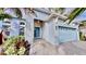 Home exterior featuring a light blue front door, stone address numbers, and a two-car garage at 5307 Wishing Arch Dr, Apollo Beach, FL 33572