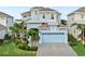 Charming three-story home features a light blue exterior, attached two car garage and beautiful landscaping at 5307 Wishing Arch Dr, Apollo Beach, FL 33572