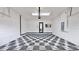 Clean, organized garage with a checkered tile floor, tv, and a door leading to the outside at 5307 Wishing Arch Dr, Apollo Beach, FL 33572