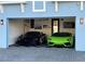Spacious garage with an open entrance, featuring two luxury vehicles and decorative wall art at 5307 Wishing Arch Dr, Apollo Beach, FL 33572