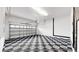 Garage space with checkered flooring, open door, garage door, and side storage areas at 5307 Wishing Arch Dr, Apollo Beach, FL 33572