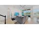 Open-concept living room with modern furniture, ceiling fan, and water views through sliding glass doors at 5307 Wishing Arch Dr, Apollo Beach, FL 33572