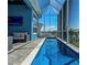 Long in-ground pool with a view of the canal on a screened-in lanai with outdoor seating at 5307 Wishing Arch Dr, Apollo Beach, FL 33572