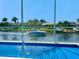 View of a passing boat from the pool area overlooking the water and surrounding tropical landscape at 5307 Wishing Arch Dr, Apollo Beach, FL 33572