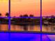 An in-ground pool overlooks a vibrant sunset, tropical landscaping, and waterfront views at 5307 Wishing Arch Dr, Apollo Beach, FL 33572