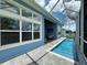 The back patio boasts a long swimming pool, light blue house exterior, and full screen enclosure at 5307 Wishing Arch Dr, Apollo Beach, FL 33572