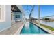 Screened-in lanai featuring a long pool, comfortable seating, and a view of the water at 5307 Wishing Arch Dr, Apollo Beach, FL 33572
