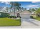 Beautiful one-story home with a two-car garage, lush lawn and manicured landscaping at 5422 Braddock Dr, Zephyrhills, FL 33541