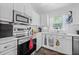 Bright eat-in kitchen featuring stainless steel appliances, white cabinetry, and tiled floors at 5422 Braddock Dr, Zephyrhills, FL 33541