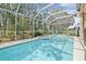 Sparkling screened in pool and attached hot tub with serene wooded backyard views at 5422 Braddock Dr, Zephyrhills, FL 33541