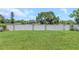 Well-manicured backyard with a lush green lawn and white perimeter fencing at 5741 91St N Ave, Pinellas Park, FL 33782