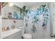 Bathroom with a marble-themed wall, blue floral shower curtain, and decorated mirror at 5741 91St N Ave, Pinellas Park, FL 33782