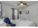 Bedroom featuring a ceiling fan and window with blue patterned curtains at 5741 91St N Ave, Pinellas Park, FL 33782