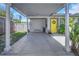 Bright yellow front door with wreath, sheltered by a carport, surrounded by lush landscaping at 5741 91St N Ave, Pinellas Park, FL 33782