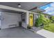 Covered carport leading to a yellow front door with a wreath, accented by greenery and stylish details at 5741 91St N Ave, Pinellas Park, FL 33782