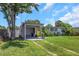 Single-story home featuring a carport and bright yellow front door, complemented by lush landscaping at 5741 91St N Ave, Pinellas Park, FL 33782