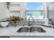 Double stainless steel kitchen sink with tile backsplash and marble countertops located near a window at 5741 91St N Ave, Pinellas Park, FL 33782