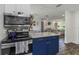 Open concept kitchen with stainless steel appliances and blue cabinets overlooking the living area at 5741 91St N Ave, Pinellas Park, FL 33782