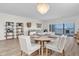 Coastal style dining area with seating for four, chandelier, and view of the living room and balcony at 602 Lime Ave # 102, Clearwater, FL 33756