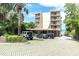 Exterior shot of a modern condo building with balconies, covered parking, and verdant surroundings at 602 Lime Ave # 102, Clearwater, FL 33756