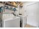 Functional laundry room with washer, dryer, and wire shelving for storage at 7046 Frascati Loop, Wesley Chapel, FL 33544