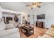 Open-concept living room with wood floors, a ceiling fan, and a mounted television at 7046 Frascati Loop, Wesley Chapel, FL 33544