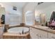 Bright bathroom with soaking tub, double sinks, and white cabinets at 7046 Frascati Loop, Wesley Chapel, FL 33544