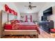 Bright main bedroom featuring hardwood floors, a large bed, and dark-wood furniture at 7046 Frascati Loop, Wesley Chapel, FL 33544