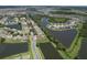 An aerial view of a residential neighborhood featuring homes, streets, lakes, and ponds surrounded by greenery at 7254 Parkersburg Dr, Wesley Chapel, FL 33545