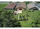 An aerial shot of a backyard with a patio, outdoor kitchen, and landscaped yard, nestled among trees and neighboring homes at 7254 Parkersburg Dr, Wesley Chapel, FL 33545