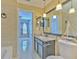 Well-lit bathroom with granite vanity and a clear view into a bedroom with striped walls at 7254 Parkersburg Dr, Wesley Chapel, FL 33545