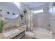 Modern bathroom with a granite vanity, round mirror, and bathtub-shower combo with stylish accents at 7254 Parkersburg Dr, Wesley Chapel, FL 33545