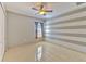 Neutral bedroom featuring decorative striped walls, tile flooring, and an attached closet at 7254 Parkersburg Dr, Wesley Chapel, FL 33545