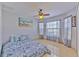 Bright bedroom with natural light, a ceiling fan, and charming Paris-themed bedding at 7254 Parkersburg Dr, Wesley Chapel, FL 33545