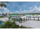 A large community pool area with a beach, lounge chairs, and a water slide on a sunny day with cloudy skies at 7254 Parkersburg Dr, Wesley Chapel, FL 33545
