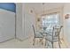 Bright dining area features a glass table, decorative lighting, and a window with sheer curtains at 7254 Parkersburg Dr, Wesley Chapel, FL 33545