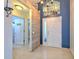 Foyer with a view to the bath and a decorative wall leading to front door with transom window at 7254 Parkersburg Dr, Wesley Chapel, FL 33545