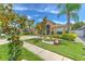 Beautifully landscaped front yard of home with mature trees, lush green lawn and inviting walkway at 7254 Parkersburg Dr, Wesley Chapel, FL 33545