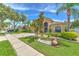 Well-manicured front yard with mature trees, lush landscaping, and a spacious driveway at 7254 Parkersburg Dr, Wesley Chapel, FL 33545
