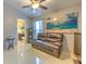 Cozy living room with leather sofa, tile flooring, and partial view of an adjacent bathroom at 7254 Parkersburg Dr, Wesley Chapel, FL 33545