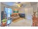 Cozy living room featuring a leather sofa, tile flooring, and a ceiling fan at 7254 Parkersburg Dr, Wesley Chapel, FL 33545