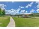 View of a community park featuring a playground, covered seating area, and walking path in a well-maintained setting at 7254 Parkersburg Dr, Wesley Chapel, FL 33545