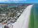 Stunning aerial view of coastal real estate along a pristine white sand beach and clear turquoise water at 745 Bruce Ave, Clearwater Beach, FL 33767