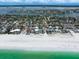 Expansive aerial view showcases beautiful coastal homes along a pristine white sand beach and clear blue water at 745 Bruce Ave, Clearwater Beach, FL 33767